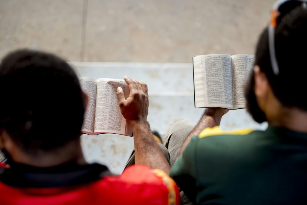 Overhead shot of people sitting and reading the bible with a blurred background